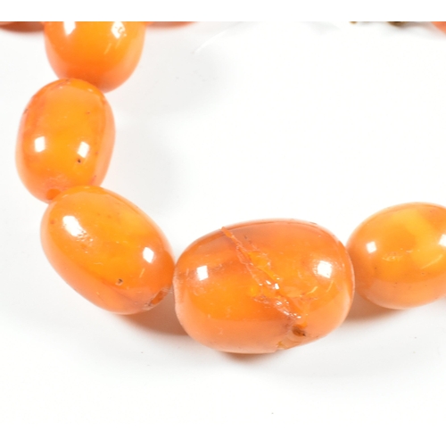 17 - An vintage amber bead necklace. The amber necklace having graduating oval beads strung with later cl... 