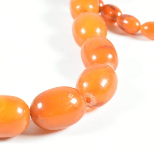 17 - An vintage amber bead necklace. The amber necklace having graduating oval beads strung with later cl... 