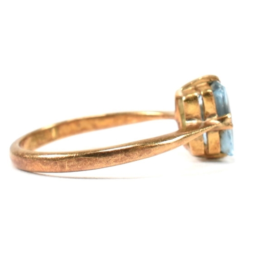 177 - A 22ct gold and blue stone ring. The ring set with a single double claw set baguette cut blue stone ... 