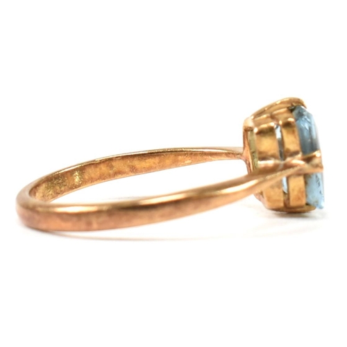 177 - A 22ct gold and blue stone ring. The ring set with a single double claw set baguette cut blue stone ... 