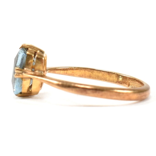 177 - A 22ct gold and blue stone ring. The ring set with a single double claw set baguette cut blue stone ... 