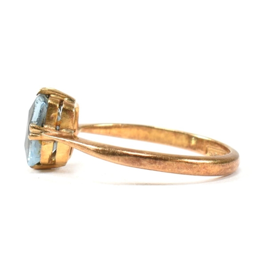 177 - A 22ct gold and blue stone ring. The ring set with a single double claw set baguette cut blue stone ... 