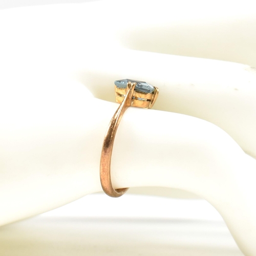 177 - A 22ct gold and blue stone ring. The ring set with a single double claw set baguette cut blue stone ... 