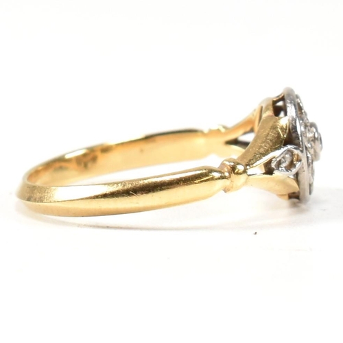 18 - An 18ct gold and diamond cluster ring. The ring having a central bezel set round brilliant cut diamo... 