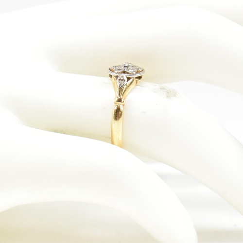 18 - An 18ct gold and diamond cluster ring. The ring having a central bezel set round brilliant cut diamo... 