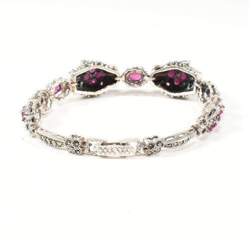 189 - A 925 silver, marcasite and ruby set double panther head bracelet. The silver bracelet having two pa... 