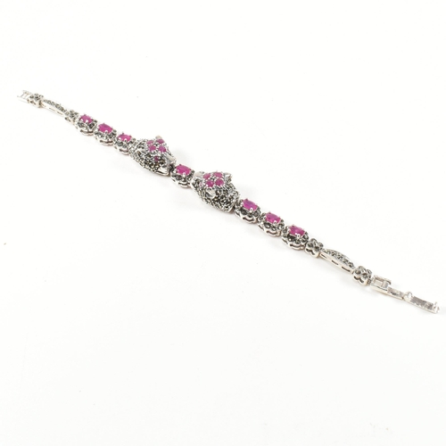 189 - A 925 silver, marcasite and ruby set double panther head bracelet. The silver bracelet having two pa... 