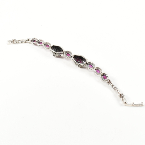 189 - A 925 silver, marcasite and ruby set double panther head bracelet. The silver bracelet having two pa... 