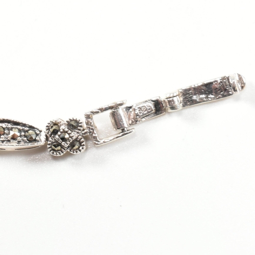 189 - A 925 silver, marcasite and ruby set double panther head bracelet. The silver bracelet having two pa... 