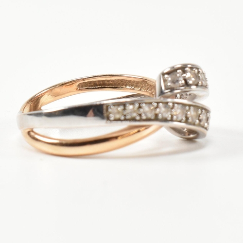 193 - A 14ct white and rose gold and CZ set twist ring. The intertwined multi-tone ring having a white gol... 