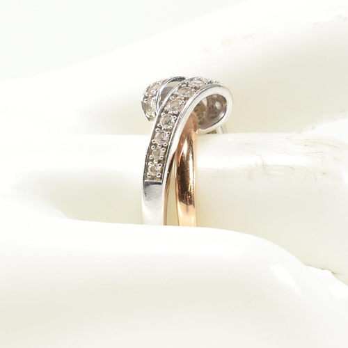 193 - A 14ct white and rose gold and CZ set twist ring. The intertwined multi-tone ring having a white gol... 