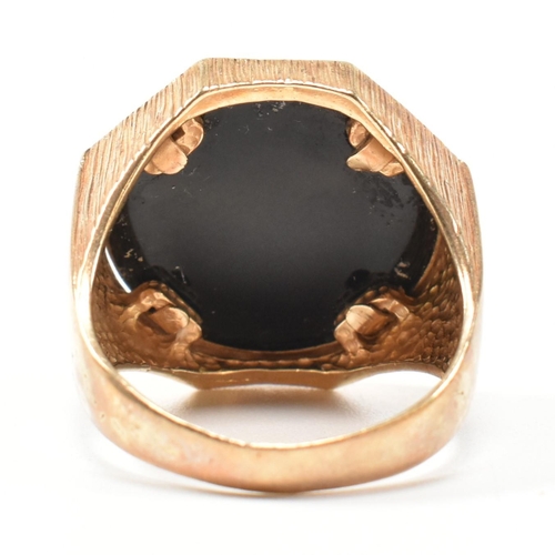 195 - A hallmarked 9ct gold signet ring having an onyx plaque with incised gilded cannabis leaf motif havi... 