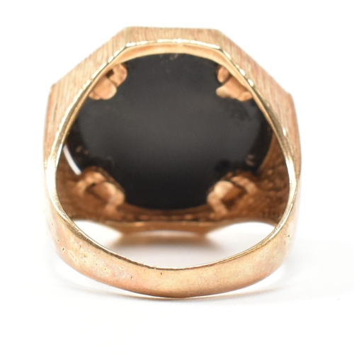 195 - A hallmarked 9ct gold signet ring having an onyx plaque with incised gilded cannabis leaf motif havi... 