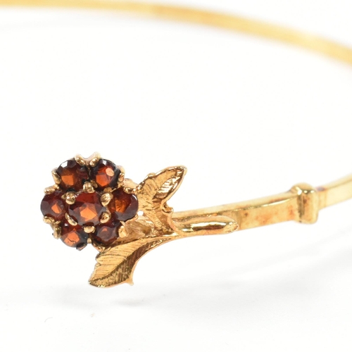 196 - A hallmarked 9ct gold and garnet flower cluster torque bangle. The 9ct gold torque bangle set with f... 