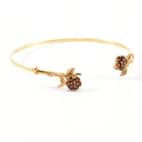 196 - A hallmarked 9ct gold and garnet flower cluster torque bangle. The 9ct gold torque bangle set with f... 