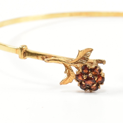 196 - A hallmarked 9ct gold and garnet flower cluster torque bangle. The 9ct gold torque bangle set with f... 