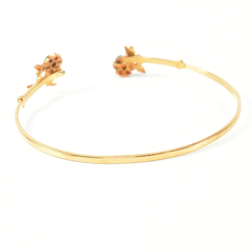 196 - A hallmarked 9ct gold and garnet flower cluster torque bangle. The 9ct gold torque bangle set with f... 