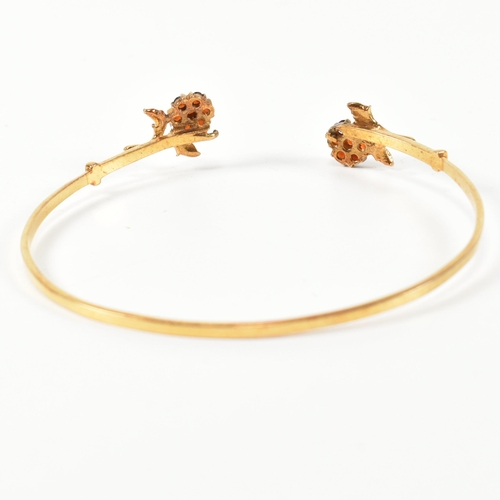 196 - A hallmarked 9ct gold and garnet flower cluster torque bangle. The 9ct gold torque bangle set with f... 