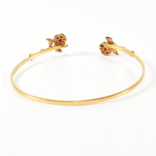 196 - A hallmarked 9ct gold and garnet flower cluster torque bangle. The 9ct gold torque bangle set with f... 