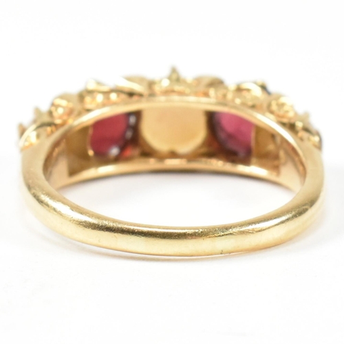 20 - A gold pearl and garnet and diamond five stone ring. The ring set with three half pearls and two rou... 