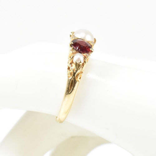 20 - A gold pearl and garnet and diamond five stone ring. The ring set with three half pearls and two rou... 