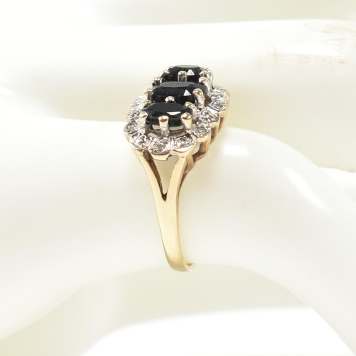 206 - A 9ct gold, sapphire and diamond three stone ring. The ring set with three graduating oval cut sapph... 