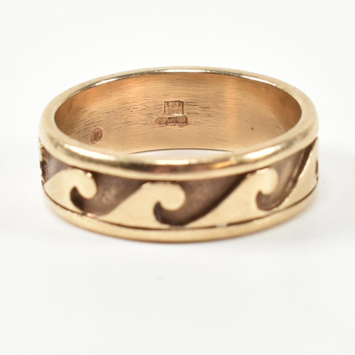 213 - A hallmarked 9ct gold wave design band ring. The 9ct gold surf theme ring having a relief wave desig... 