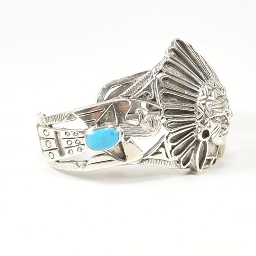 216 - A 925 silver and turquoise cuff bangle. The silver bangle set with two bezel set oval cut cabochons ... 