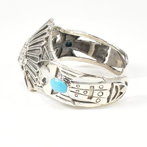 216 - A 925 silver and turquoise cuff bangle. The silver bangle set with two bezel set oval cut cabochons ... 