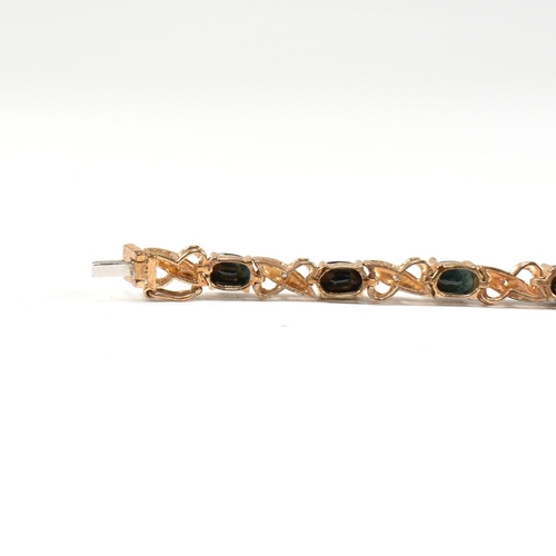 218 - A 9ct gold, sapphire and diamond line bracelet. The bracelet having fourteen oval cut sapphires inte... 