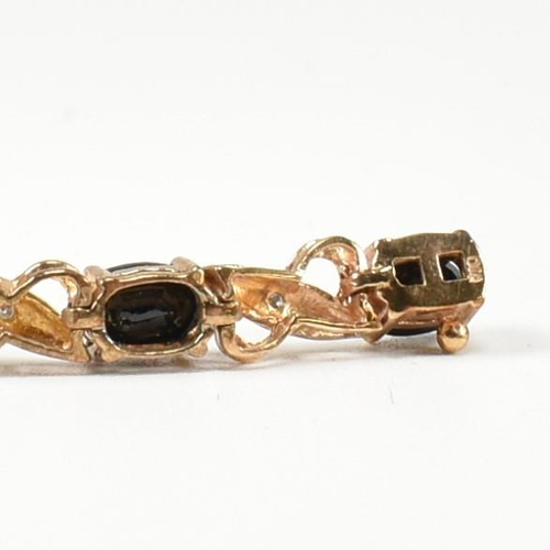 218 - A 9ct gold, sapphire and diamond line bracelet. The bracelet having fourteen oval cut sapphires inte... 