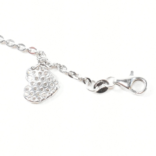 232 - A hallmarked 9ct white gold and CZ heart charm bracelet. The cable link chain bracelet having four C... 