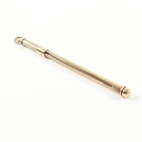 241 - A retro hallmarked 9ct gold champagne swizzle stick fob. The vintage cocktail stirrer having an engi... 