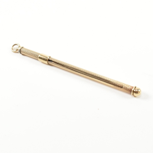 241 - A retro hallmarked 9ct gold champagne swizzle stick fob. The vintage cocktail stirrer having an engi... 