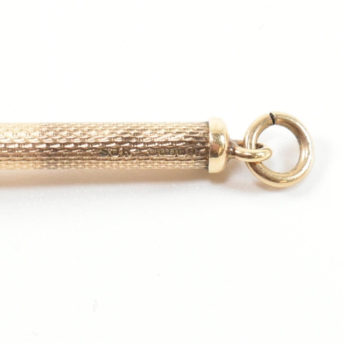 241 - A retro hallmarked 9ct gold champagne swizzle stick fob. The vintage cocktail stirrer having an engi... 