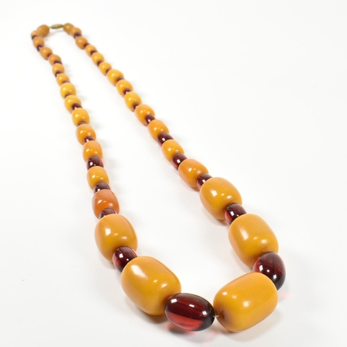 247 - A 20th century yellow and cherry Bakelite bead necklace. The necklace having thirty one graduating b... 