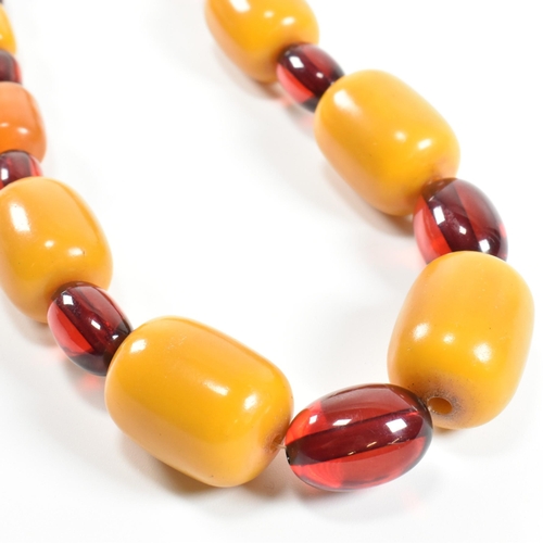 247 - A 20th century yellow and cherry Bakelite bead necklace. The necklace having thirty one graduating b... 