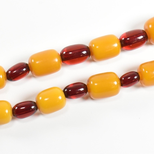 247 - A 20th century yellow and cherry Bakelite bead necklace. The necklace having thirty one graduating b... 