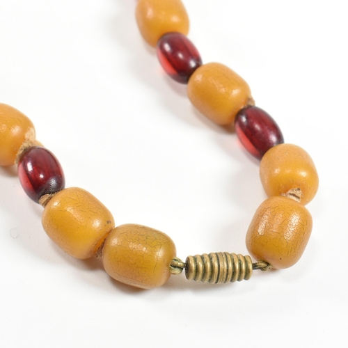 247 - A 20th century yellow and cherry Bakelite bead necklace. The necklace having thirty one graduating b... 