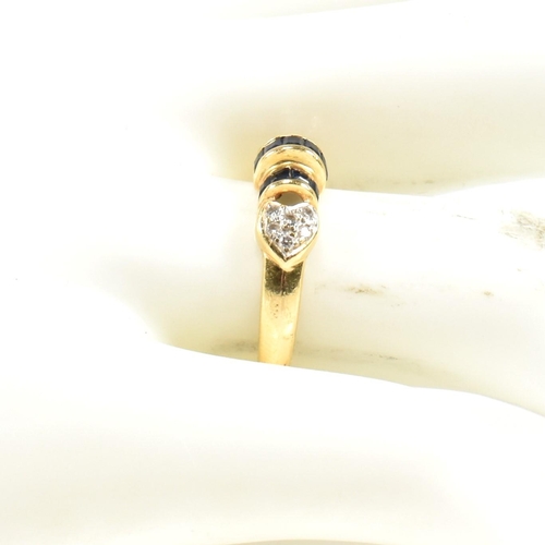 250A - An 18ct yellow gold sapphire and diamond ring. The ring having central domed calibre cut sapphires t... 