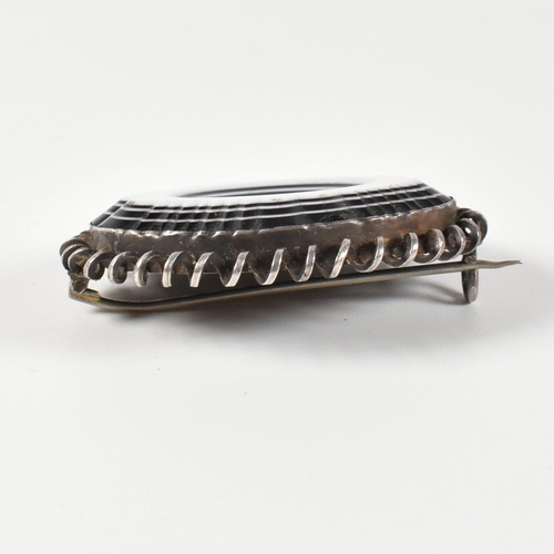 252 - A late Georgian/early Victorian carved bull's eye banded agate brooch pin. The brooch pin having a c... 