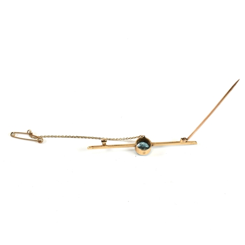 264 - A 15ct gold and zircon brooch pin. The 15ct gold brooch pin having a central bezel set round cut blu... 