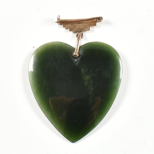 279 - A gold and nephrite jade heart pendant brooch pin. The brooch pin having a carved nephrite jade hear... 