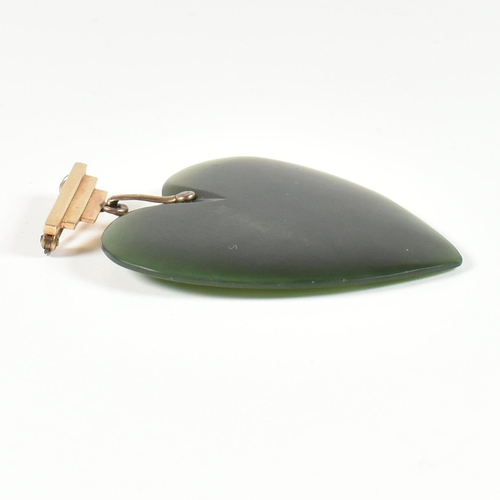 279 - A gold and nephrite jade heart pendant brooch pin. The brooch pin having a carved nephrite jade hear... 