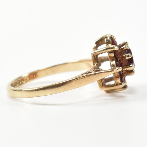 283 - A hallmarked 9ct gold and garnet cluster ring. The cluster ring having a central round cut garnet su... 