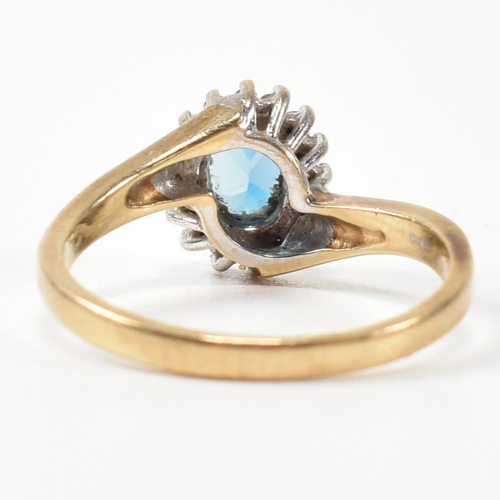 298 - A hallmarked 9ct gold, diamond and topaz cross over cluster ring. The ring having with a central ova... 