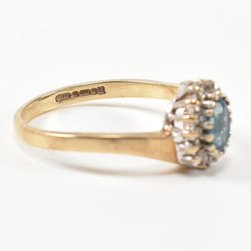 298 - A hallmarked 9ct gold, diamond and topaz cross over cluster ring. The ring having with a central ova... 