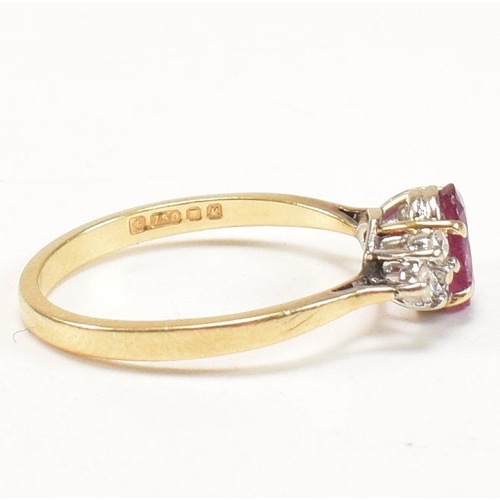 30 - A hallmarked 18ct gold, ruby and diamond ring. The ring set with a central oval cut ruby flanked by ... 