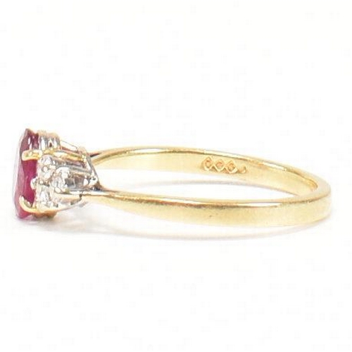 30 - A hallmarked 18ct gold, ruby and diamond ring. The ring set with a central oval cut ruby flanked by ... 