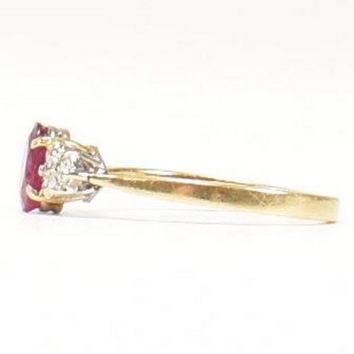 30 - A hallmarked 18ct gold, ruby and diamond ring. The ring set with a central oval cut ruby flanked by ... 